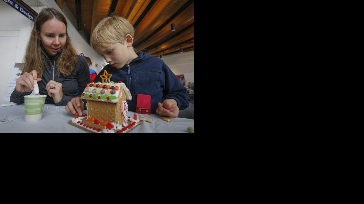 
Jana Phillips and her son Gordy work on a gingerbread house Saturday at the Gingerbread Village event at Exploration Place. The annual event continues from 11 a.m. to 5 p.m. Sunday. 

