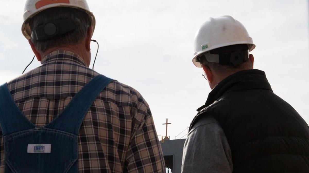 Tim Helten, left, project superintendent, and Tom Dondlinger, president of Dondlinger Construction, watch Monday as a cross is raised over the new Bishop Gerber Science Center on Newman University’s campus. (Jan. 9, 2017)