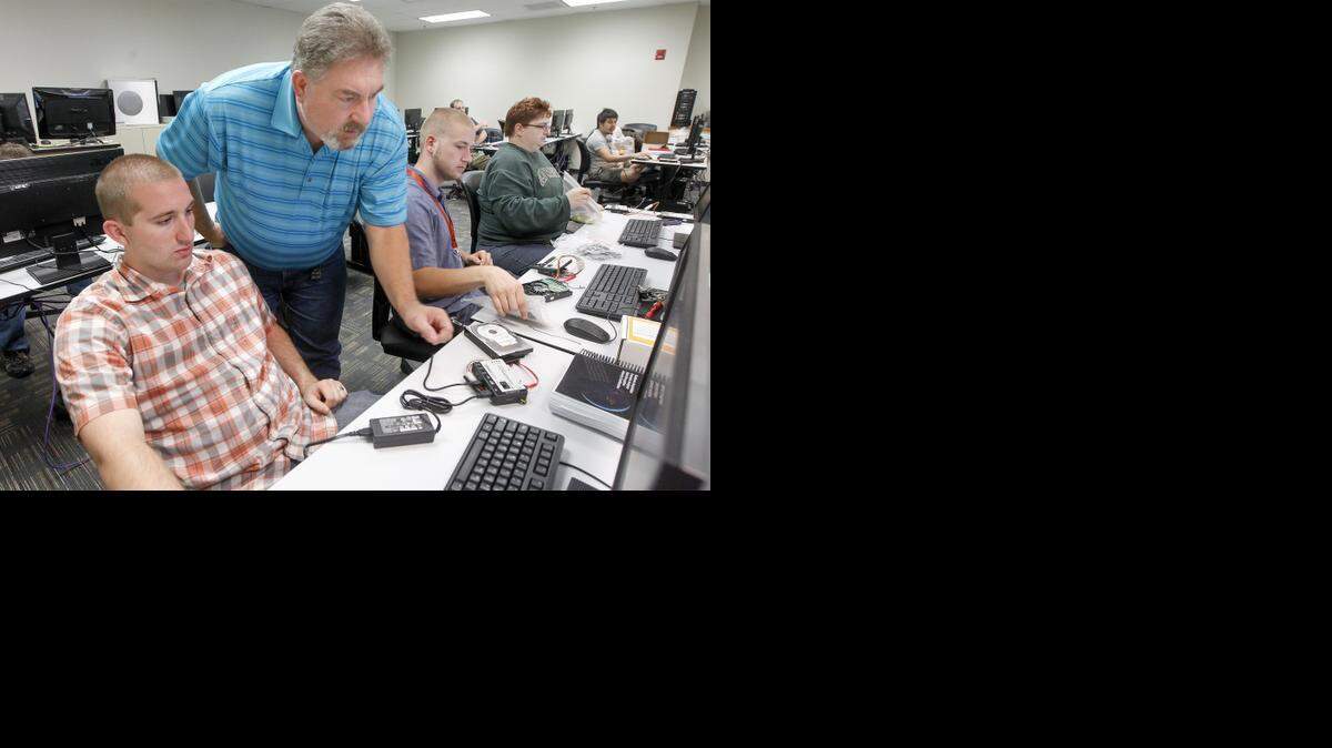 
Butler Community College instructor Brett Eisenman teaches a cybersecurity class to Mitchell Kelly, left, and Connor Brewer at Butler’s Andover campus. (Sept. 10, 2014)
