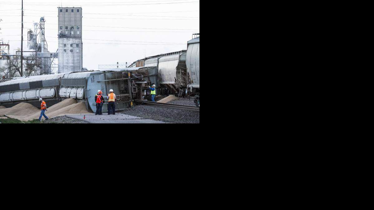 
Railroad workers investigate the derailment of three grain cars near Santa Fe south of 17th Street. Three grain cars derailed north of downtown Wichita around 5:15 Thursday morning, blocking east-west routes through much of the heart of the city. (April 2, 2015)
