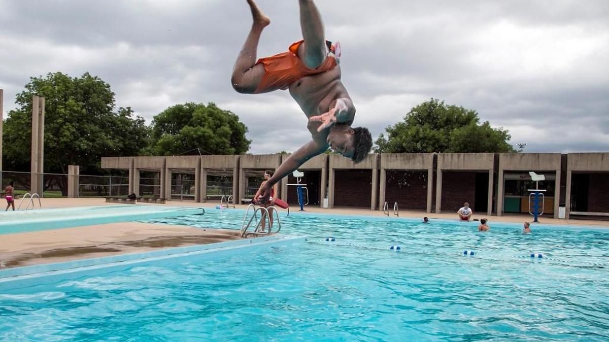 Josh McElroy, 13, does a flip off the diving board at McAdams swimming pool in July 2015.