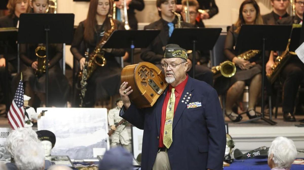 Jim Denison holds a 1940s-era radio during a commemoration Wednesday of the 75th anniversary of the attack on Pearl Harbor. The ceremony was at the Robert J. Dole VA Medical Center.