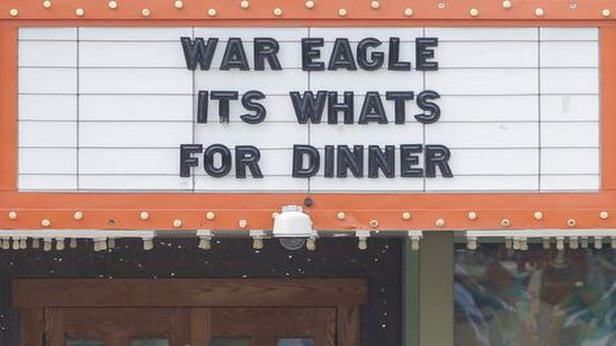 
Two Auburn football fans walk under a marquee at Varney’s in Aggieville in Manhattan on Wednesday that makes fun of the Auburn rally call “War Eagle.” Kansas State takes on Auburn on Thursday night in one of the biggest games at Bill Snyder Family Stadium in years.
