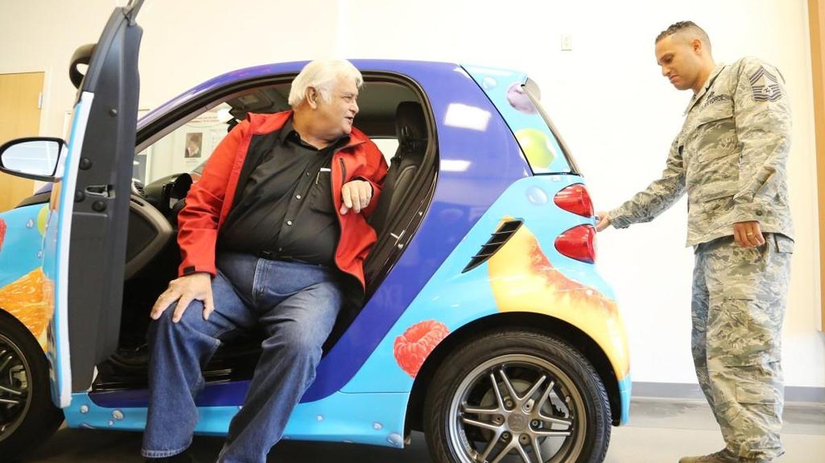 Chief Master Sgt. Luis Reyes, right, introduces veteran Lawrence Lazar as the winner of Welch’s Fruit Snacks-branded Smart Car on Wednesday morning at the McConnell Air Force Base exchange. (Jan. 18, 2017)