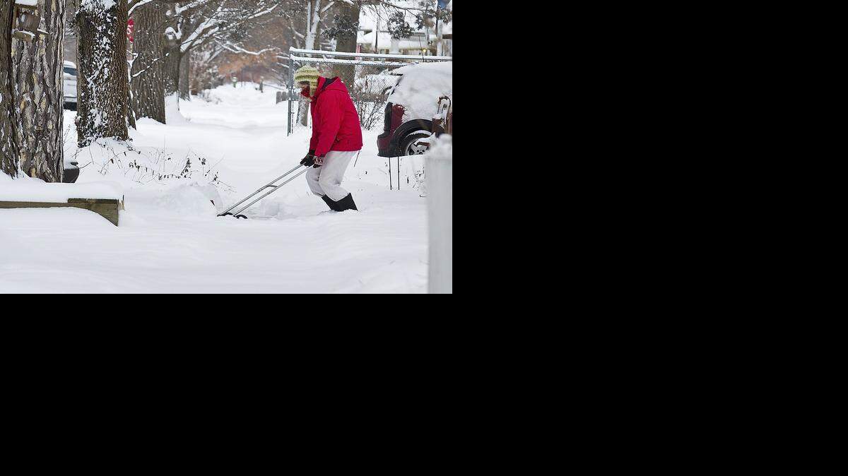 
Joann Ryan uses a hand-operated snow plow to clear her Riverside sidewalk in February. Forecasters are predicting more snow than average in Wichita this winter.
