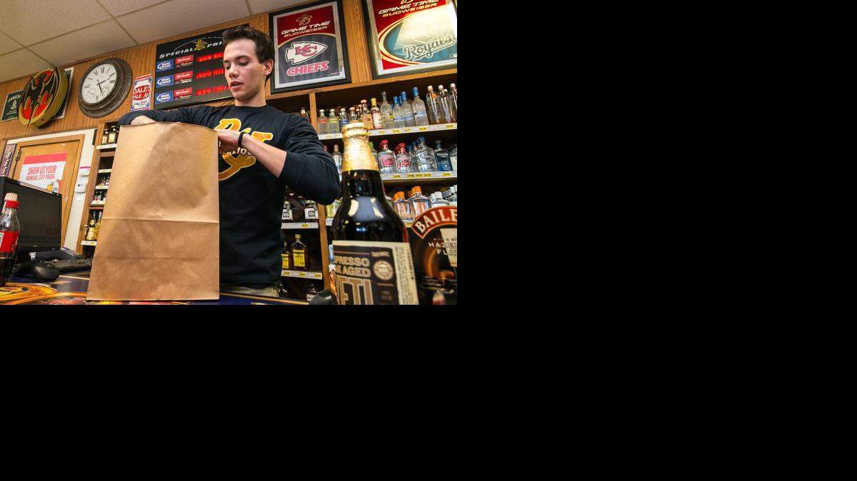 
John Love bags items for a customer at R&J Discount Liquor near Douglas and Hillside on Thursday. (Jan. 8, 2015)
