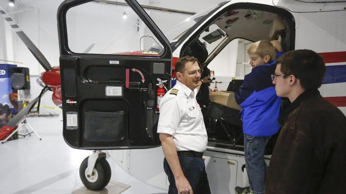 Pilot Will White talks with visitors about one of the planes used by Mission Aviation Fellowship during an open house Saturday at Mid-Continent Aviation Services.