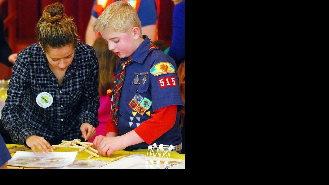 
Gavin Coronado, right, and volunteer Paula Duque build a Leonardo da Vinci bridge at the Wichita Society of Women Engineers Engineering Expo on Saturday at Century II.

