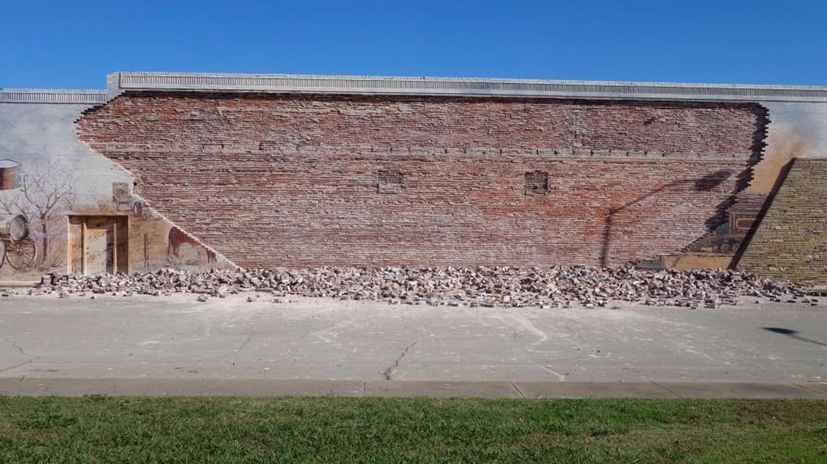 A 5.0-magnitude earthquake destroyed a mural on a wall in downtown Cushing, Okla., in November. The only part of the mural that remained, on the left, was a depiction of oil drums and containers.