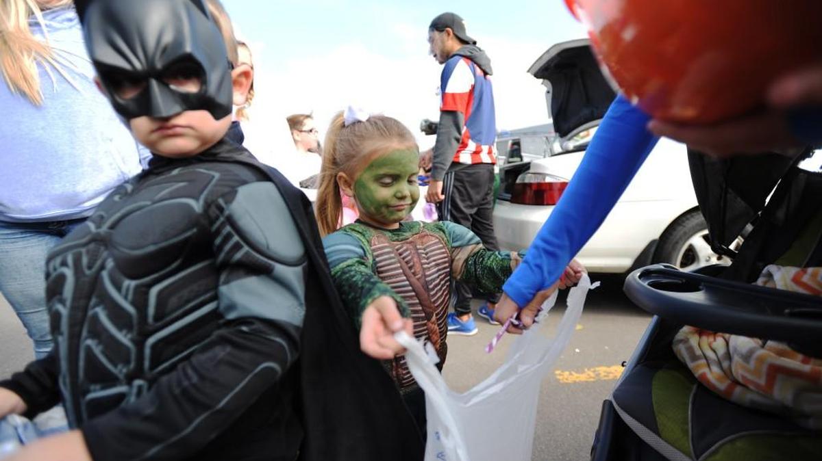 Robert Howell, 4, left, and Peyton Walker, 4, both from Stevensville, Mich., gather candy at a trick-or-treat event.