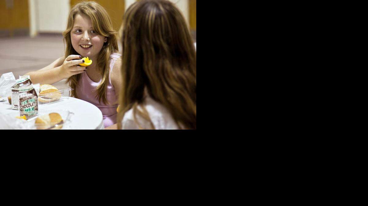 Tarryn Cline, left, visits with neighborhood friend Niki Rodriguez, during the first day of the Federal Summer Meals program at West Side Christian Church in 2010. In summer 2021, Wichita Public Schools will continue its free summer meal program through the USDA.