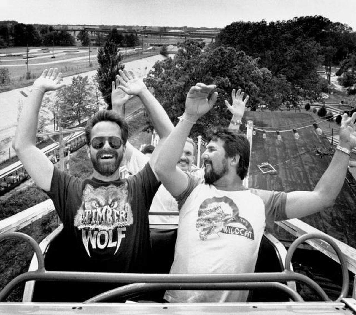 Paul Young, (left) and Sam Hughes of San Antonio, Tex., both members of the Roller Coaster Enthusiasts of America, raise their arms for the drop ahead as they enjoy the view from the highest point of the Joyland Park roller coaster in 1989.