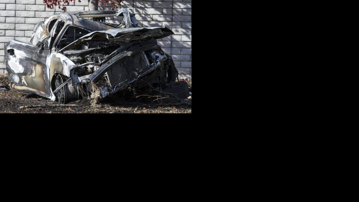
A car remains at the scene of a fatal car crash Friday morning on Woodlawn north of 21st street where one person was found dead inside a burning car. 
