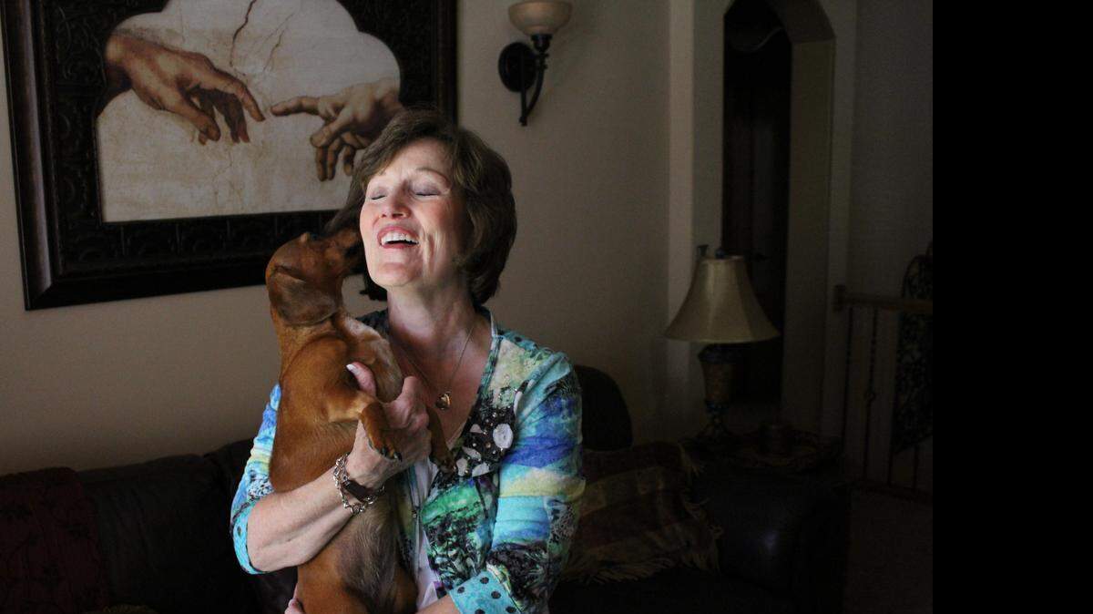 
Lucy, a 4-year-old miniature dachshund, licks her owner Rebecca Felix’s face at her Derby home Wednesday. Lucy was rescued from underneath a concrete slab in her backyard, where she had been trapped for 13 days.
