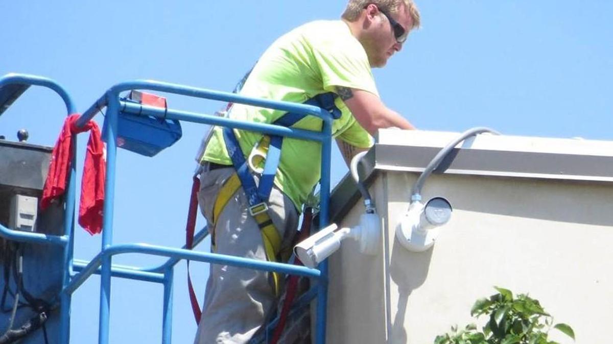 A worker installs a police surveillance camera in Old Town. The system gives police nearly 100 percent coverage of the nightlife district.