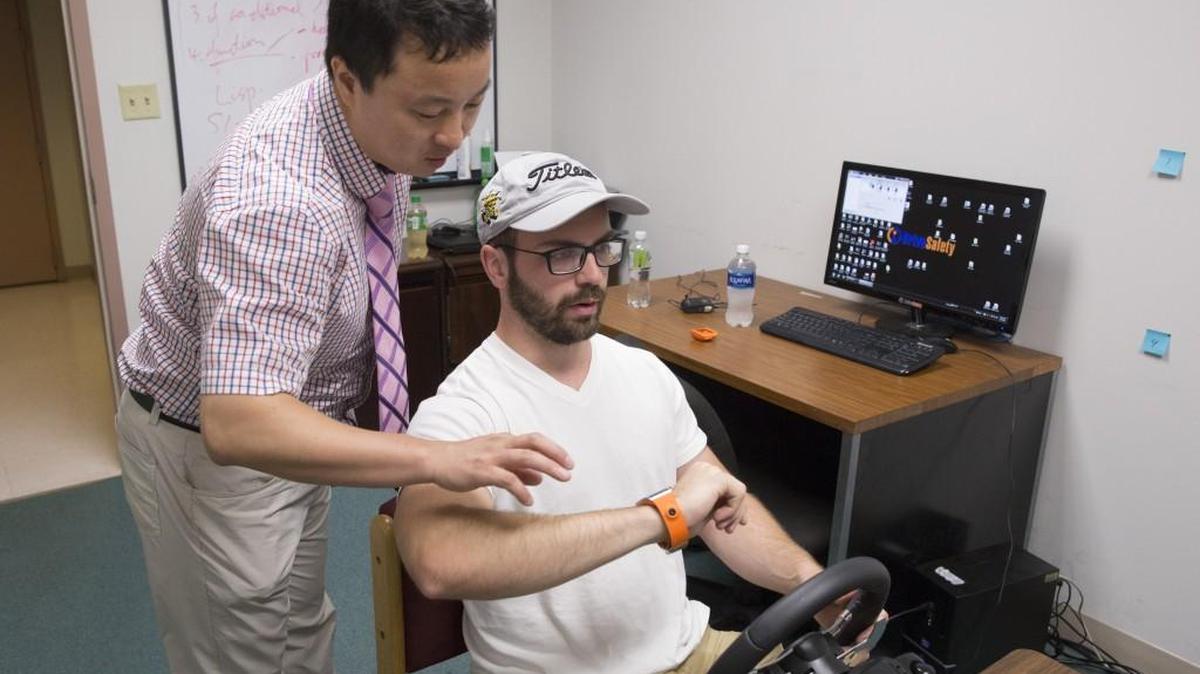 Wichita State University psychology professor Jibo He, left, conducts a lab experiment with student Daanyaal Akbar. Jibo He has researched the safety risks of people wearing smartwatches and using them while driving. His conclusion: Smartwatches are not safe to use while driving, even though you can use them almost hands-free.