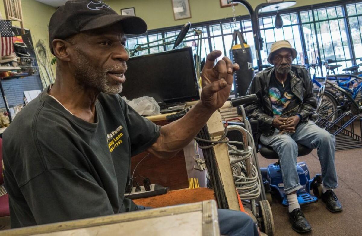“I was scared of white people,” said Wesley Mann, left, of Lucky 7 Pawn Shop. When Mann was little, his parents would not let him cross the street and told him to say “yes, sir,” and “yes, ma’am,” and not look white people in the eye.