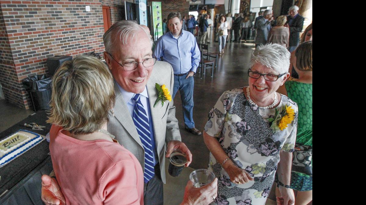 
Sedgwick County manager Bill Buchanan gets a hug Wednesday from friend and colleague Marla Flentje of Starkey during his retirement reception at Intrust Bank Arena. With him is his wife, Lynn. (June 3, 2015)
