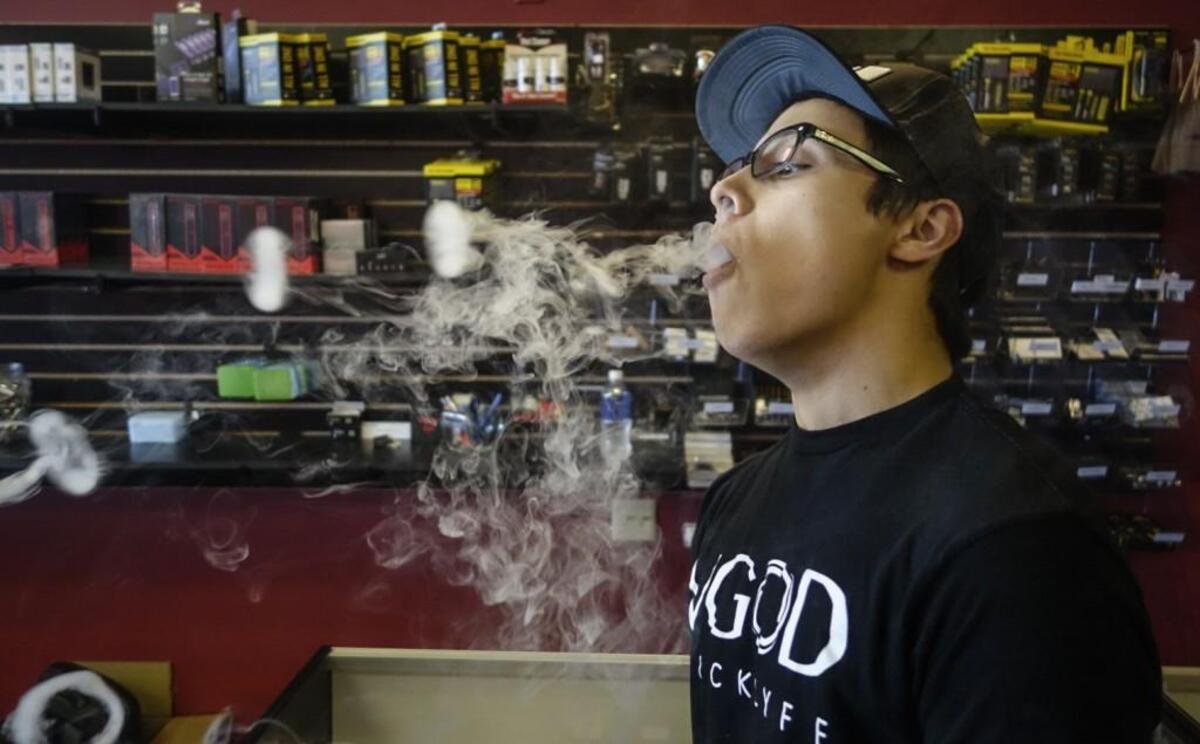 Braydn Bouddhara, an employee at Lucky’s Vape on Hillside, shows off his ability to blow smoke rings in front of the owners, Kevin Nguyen and Matt Powell.