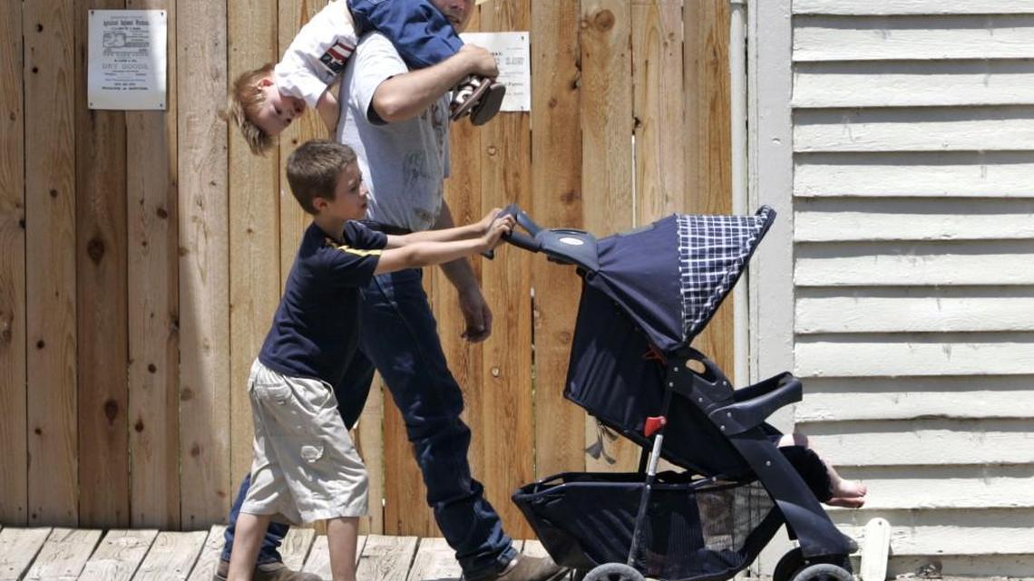A family walks along Cowtown’s wooden boardwalk in 2005. The city plans to replace the wood with a composite material.