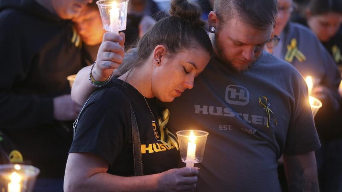 A couple embrace during a candlelight vigil at Heritage Park in Hesston on Friday night. In this predominantly Mennonite community, they pray for the victims of a mass shooting at Excel Industries. But they also pray for the shooter.
