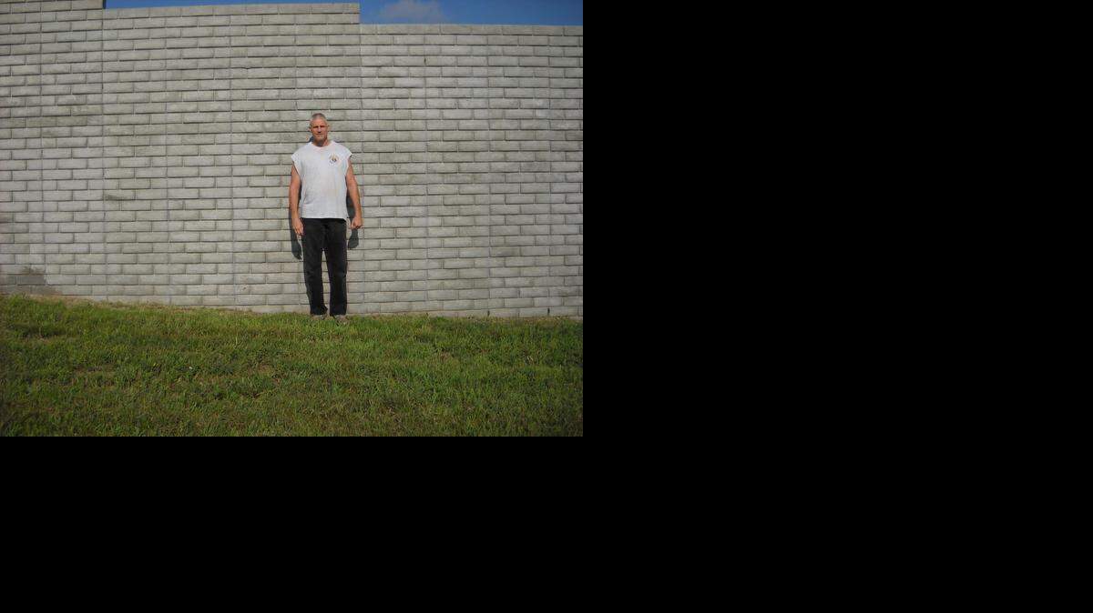 
Volunteer Jim Benck stands in front of a 10-foot-high wall that will eventually enclose the Discalced Carmelite Monastery on North Woodlawn in Valley Center.
