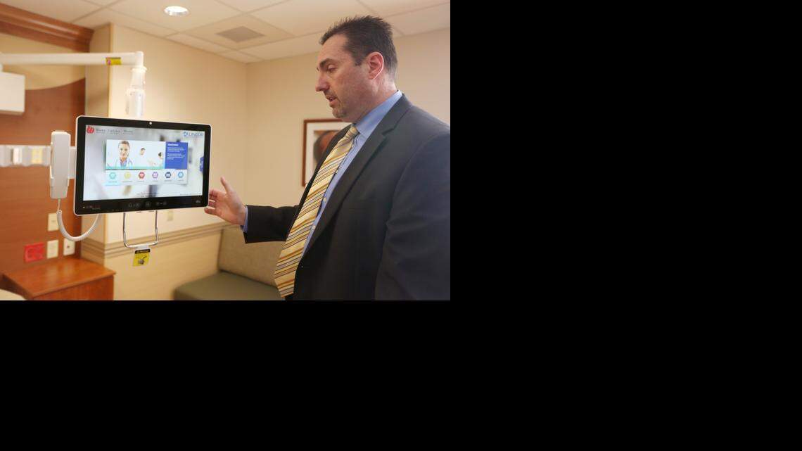 
Wesley Medical Center interim CEO Bill Voloch shows off a computer in a newly remodeled women’s birthing room. The technology serves as a Web browser, game station and movie player to which patients will have easy access because it swings over their beds. Wesley recently completed a $36 million renovation of its women’s care units.
