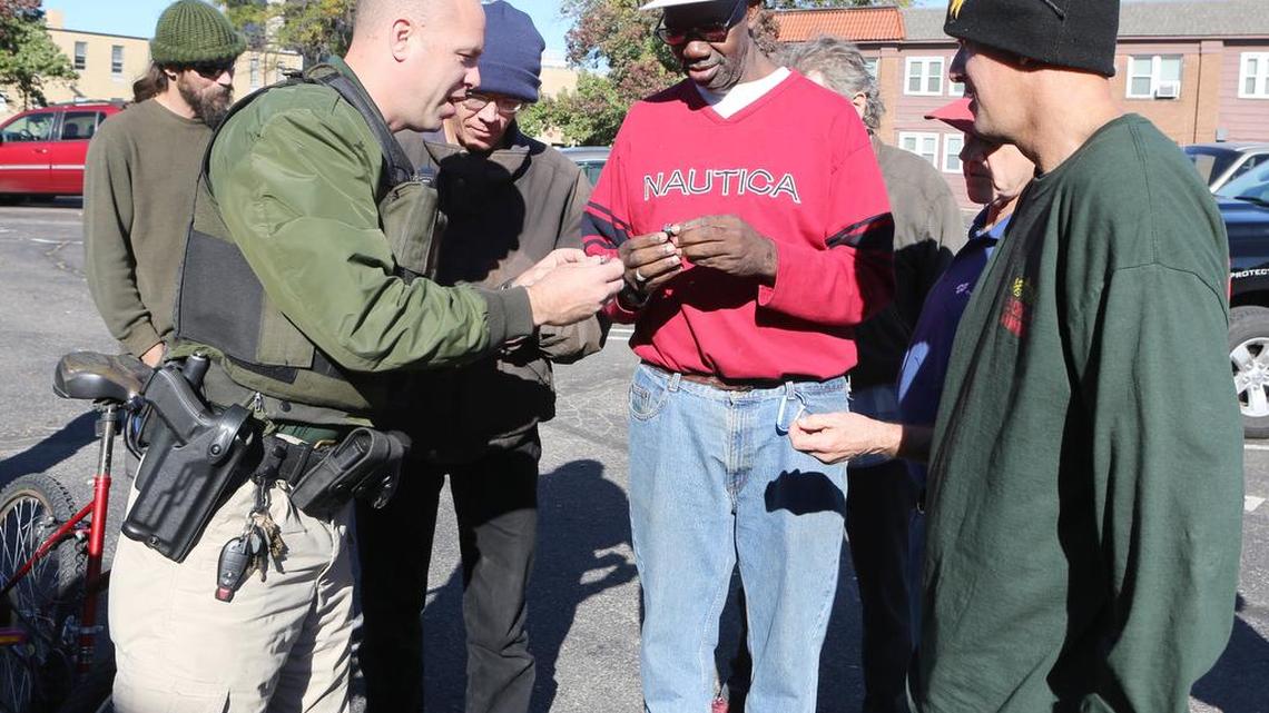 Wichita police Officer Nate Schwiethale gives away free LED bicycle lights Wednesday at United Methodist Open Door. The city gave 150 bike lights to the ministry for homeless and low-income riders. (October 28, 2015)