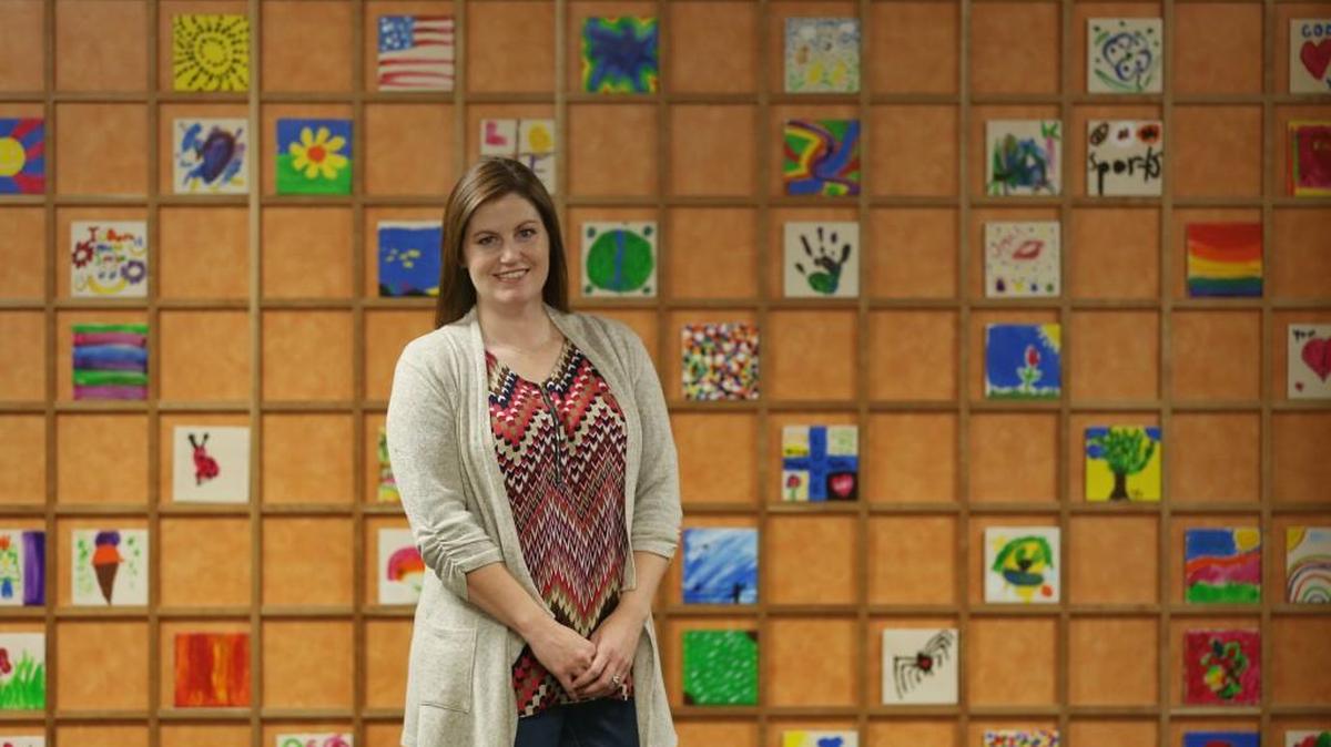 Jennifer White, director of ICT S.O.S., stands in front of a wall of ceramic tiles painted by children at the new offices at the Child Advocacy Center of Sedgwick County. ICT S.O.S. has blossomed from a grassroots effort to a key piece of an integrated approach to combat human trafficking in Wichita.