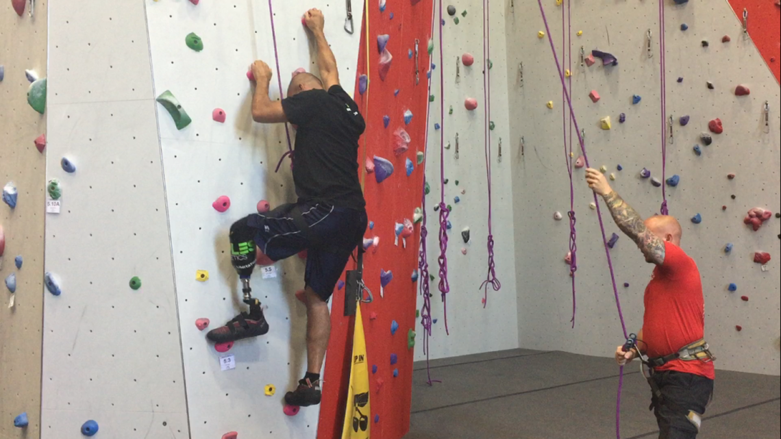 Richard Smith, left, lost his leg in a forklift accident in January. At a trial run Tuesday for Bliss Bouldering & Climbing Complex’s new adaptive climbing program, he rock climbed for the first time.