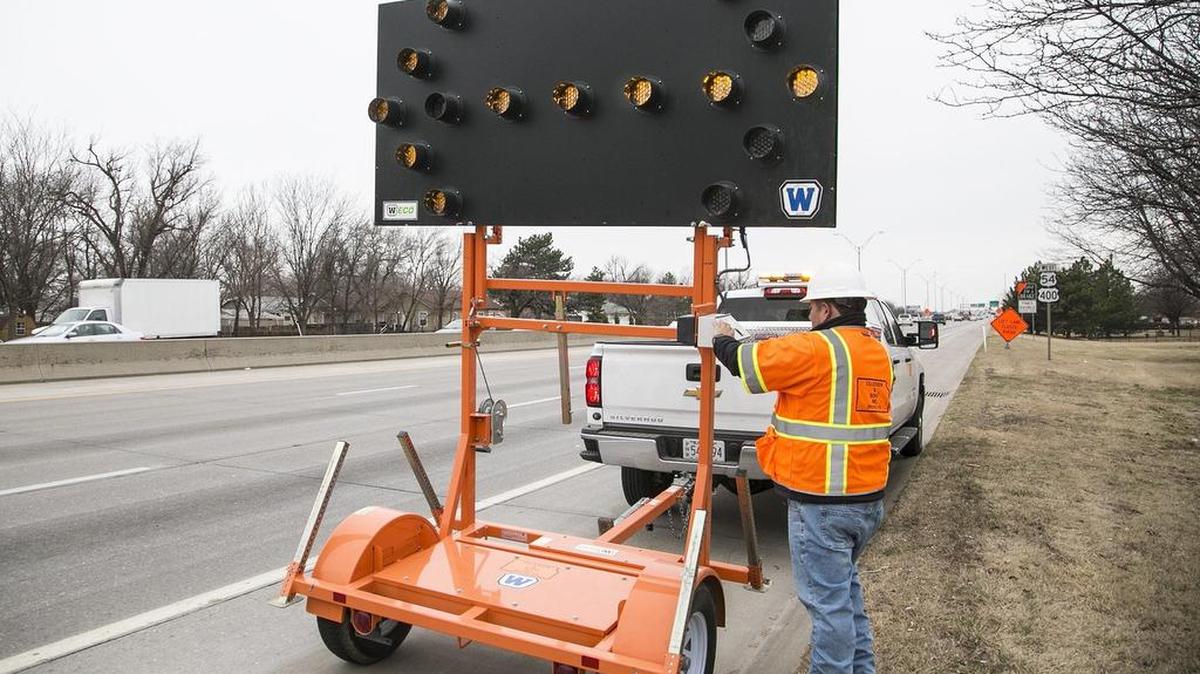 A Cillessen and Sons worker sets up a flashing arrow sign on West Kellogg Tuesday morning near Edwards where lanes will be closed Tuesday and Wednesday so Kansas Department of Transportation crews can restripe the lanes. (Feb. 23, 2016)