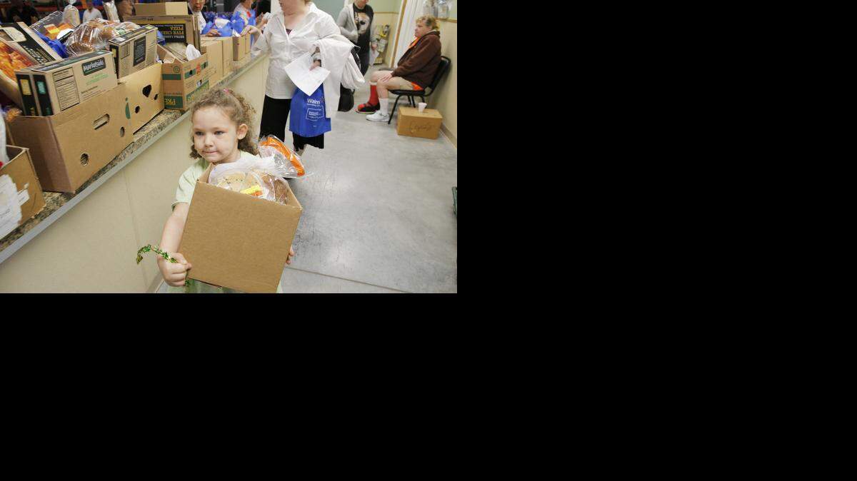 
Four-year-old Paytann Warren carries a box of food for her mother, Traci Murphy, at the Bread of Life food pantry in south Wichita on Tuesday. Murphy recently lost her job as an in-home health care provider. (Dec. 1, 2013)
