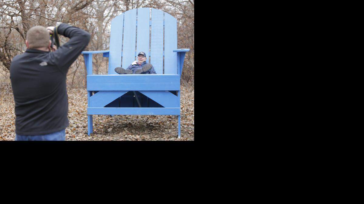 Bob Goebel, the creator of this giant, blue chair, has his photo taken at the new Memories Park at Sedgwick County Park on Saturday. (Dec. 13, 2014)