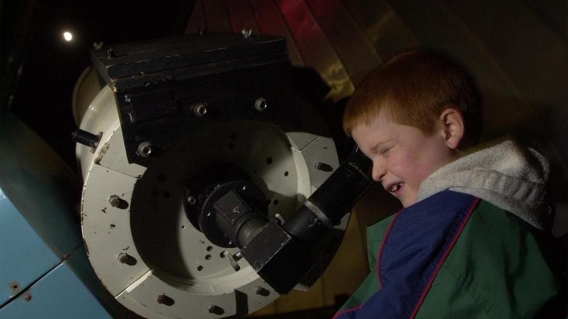 Ethan Welch looks at a lunar eclipse through the telescope at the Lake Afton Public Observatory in August. The observatory will likely reopen around Labor Day weekend.