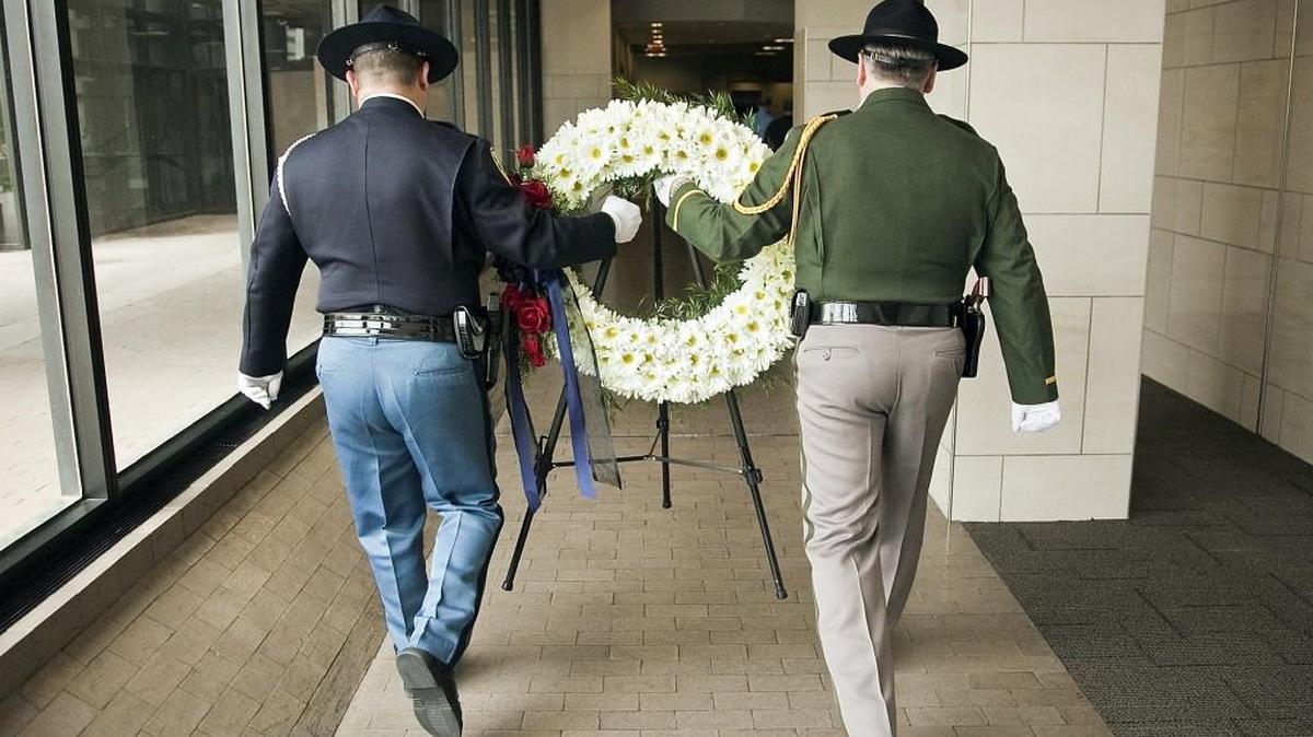 Sedgwick County sheriff’s Detective Kenneth Kooser, left, and Wichita police Sgt. Charles Newman carry the memorial wreath through Wichita City Hall after the 2014 Law Enforcement Memorial service. (May 16, 2014)