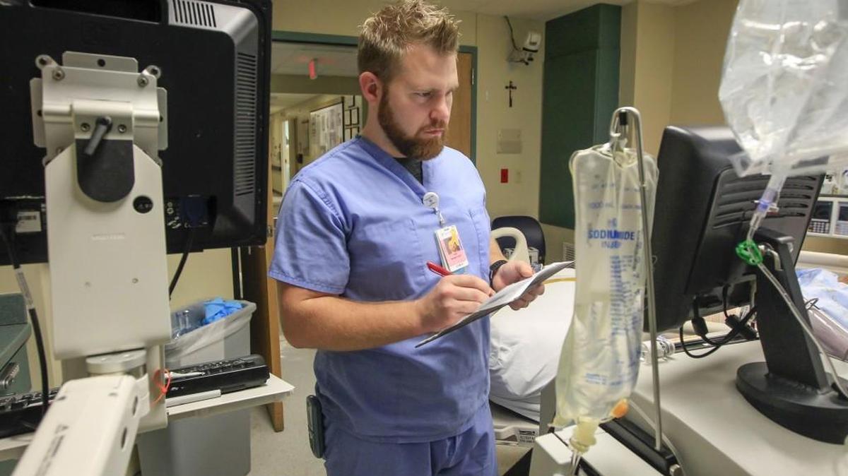 Via Christi St. Francis nurse Cody Forsberg, who just earned a doctorate nursing degree from Wichita State University, checks on a burn victim last week. Forsberg became a nurse because he was influenced by his grandfather, who was also a nurse. (Dec. 29, 2017)