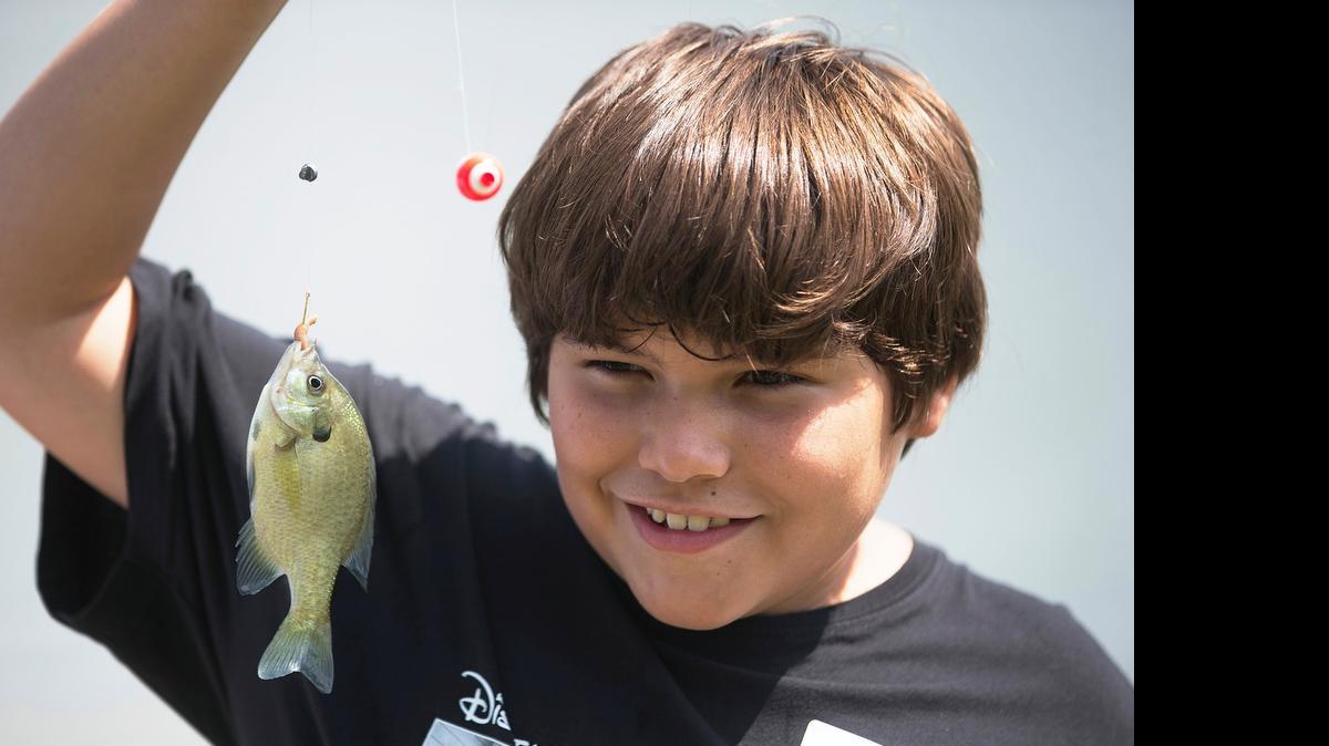 
Michael Miller holds up a fish he caught during a previous Wichita Eagle Kids Fishing Clinic at the Great Plains Nature Center. The clinic was part of the center’s annual Walk With Wildlife.
