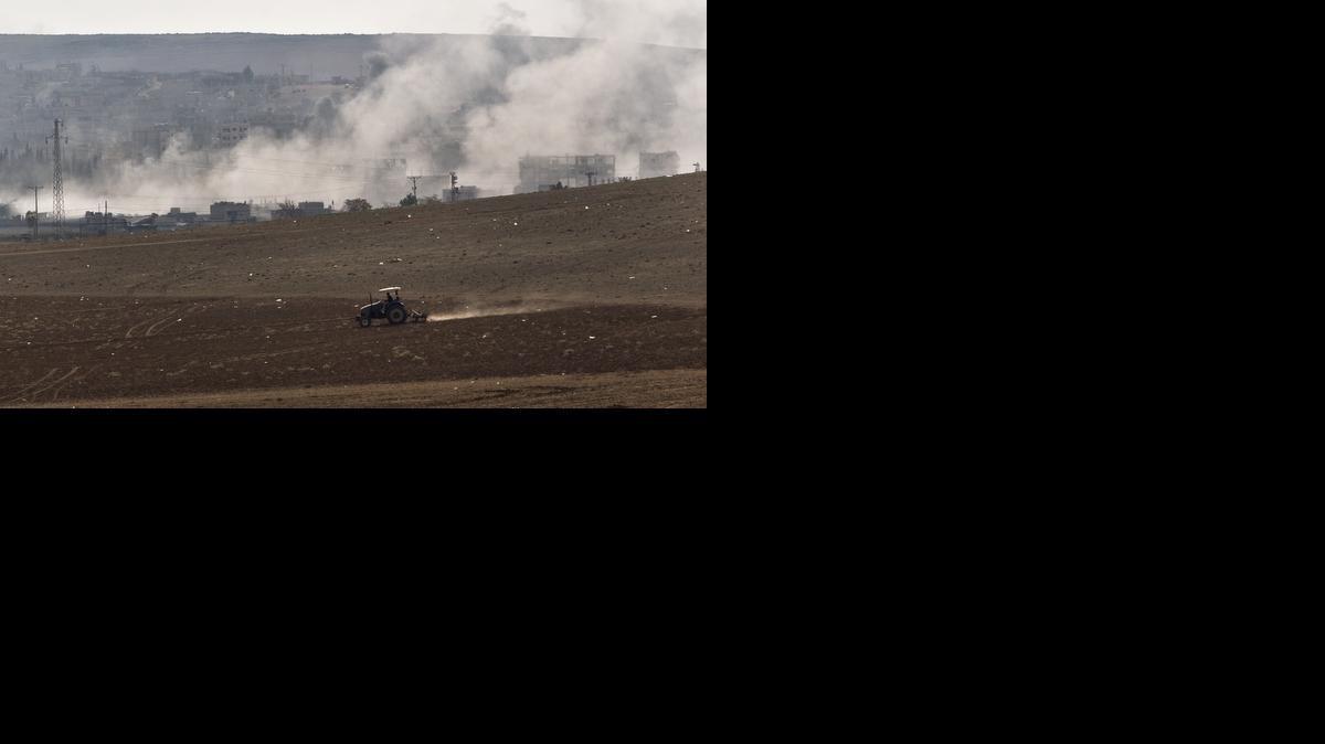 
A man ploughs a field as smoke rises from the town of Kobani during airstrikes by the U.S. led coalition, seen from the outskirts of Suruc, near the Turkey-Syria border, Tuesday.
