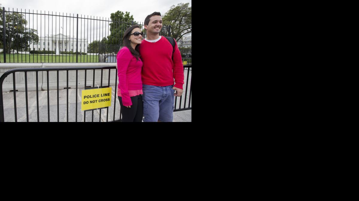 
Rodrigo Tavares and his wife, Amanda Tavares, who are visiting Washington from Brazil, pose in front of the extra layer of security barricade in front of the White House in Washington, Wednesday.
