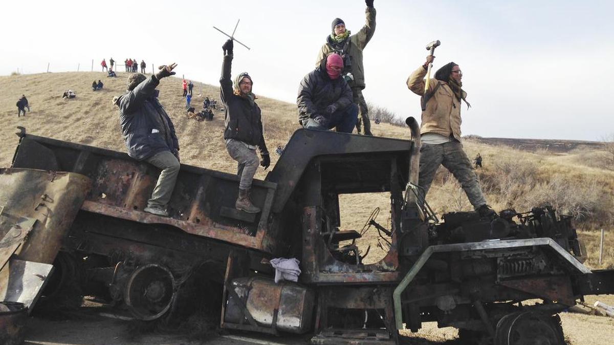 Protesters against the Dakota Access oil pipeline stand on a burned-out truck near Cannon Ball, N.D., earlier this month.