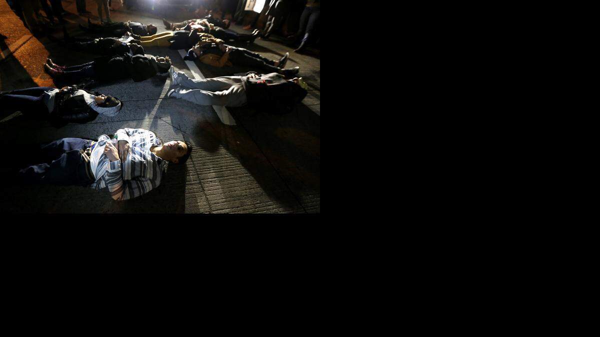 
People lie in the middle of the West Side Highway during a protest after it was announced that the New York City police officer involved in the death of Eric Garner was not indicted, Wednesday, Dec. 3, 2014, in New York. A grand jury cleared the police officer Wednesday in the videotaped chokehold death of Garner, an unarmed black man, who had been stopped on suspicion of selling loose, untaxed cigarettes.
