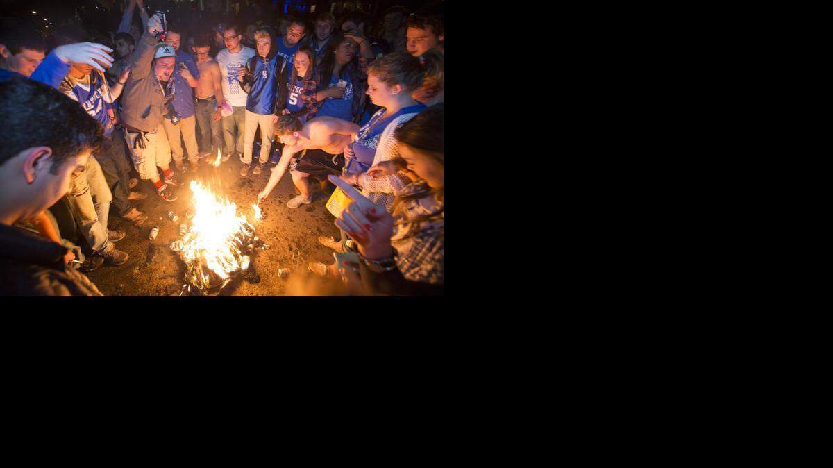 
Kentucky fans set fire to shirts and hoodies as they gather near the University of Kentucky campus, Saturday, April 4, 2015, in Lexington, Ky., after Wisconsin defeated Kentucky 71-64 in the semifinals of the NCAA men's college basketball tournament Final Four. (AP Photo/David Stephenson) 
