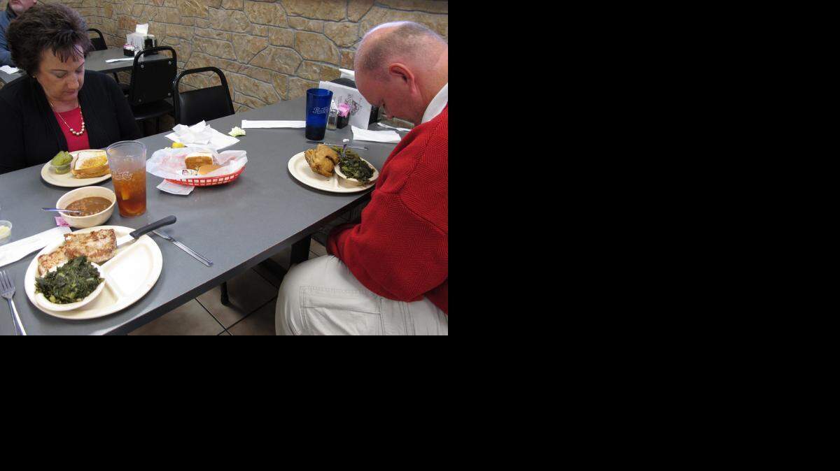 
ADVANCE FOR USE THURSDAY, NOV. 27, AND THEREAFTER- In this Oct. 31, 2014, photo, Gayle Whitehead and Scotty Reynolds bow their heads in prayer before at Southern Lunch in Lexington, N.C. Scotty says that if it weren't for Whitehead, he would be "in prison or dead." 
