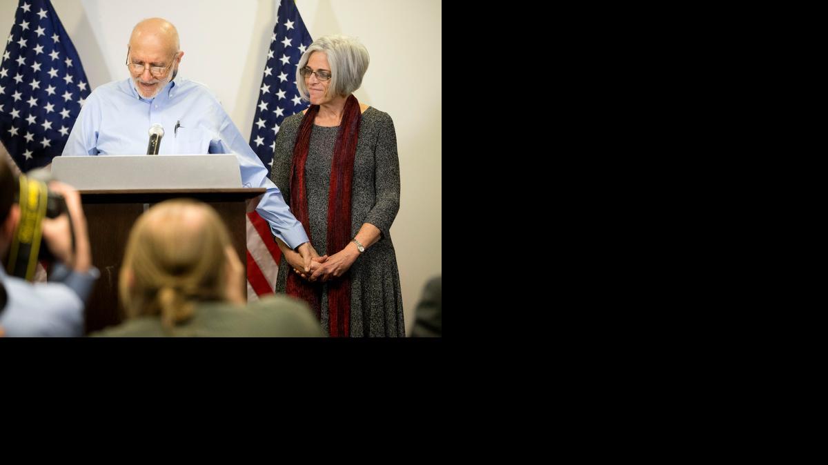 
Alan Gross holds his wife Judy's hand while during a news conference at his lawyer's office in Washington, Wednesday, Dec. 17, 2014. Gross was released from Cuba after 5 years in a Cuban prison. 
