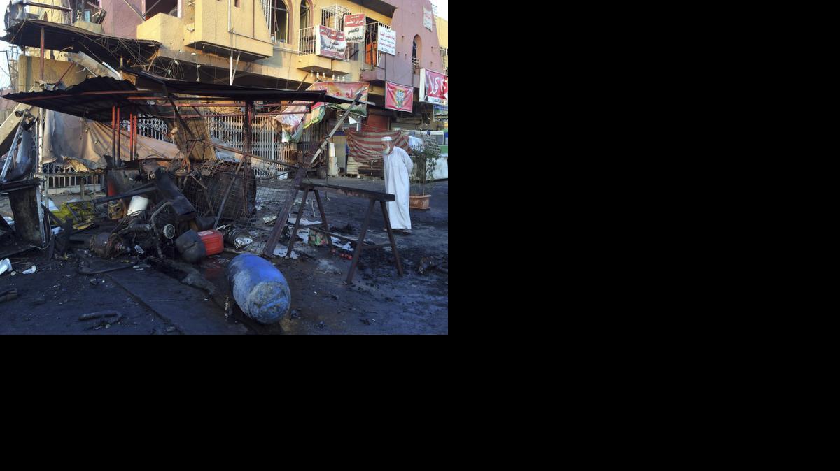 
A man inspects the aftermath of a car bomb explosion in the morning in Baghdad's eastern neighborhood of Baladiyat, Iraq, Saturday.
