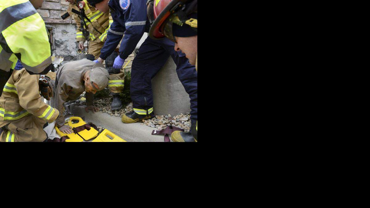 
A man trapped in a wall at the rear of Marshalls crawls out of a hole and onto a backboard, Tuesday, Nov., 11, 2014 in Longmont, Colo. Authorities say the man may have been there for several days yelling for help. 
