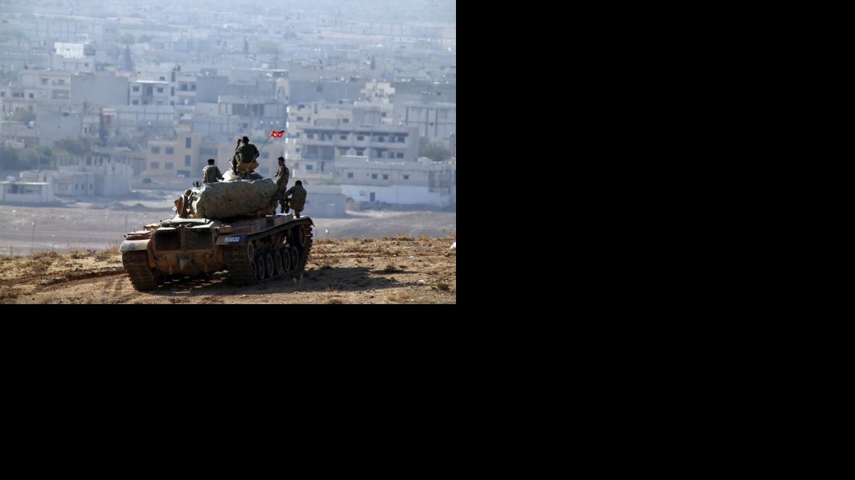 
Turkish soldiers on a tank sit on a hilltop on the outskirts of Suruc, at the Turkey-Syria border, overlooking Kobani, Syria, during fighting between Syrian Kurds and the militants of Islamic State group, Thursday.
