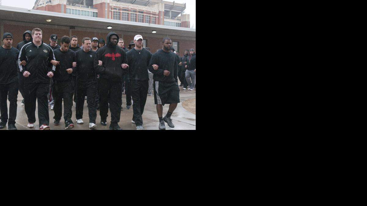 
The University of Oklahoma football team and coaches line up wearing all black in the Everest Training Center in protest of the Sigma Alpha Epsilon fraternity at the University of Oklahoma on Monday, March. 9, 2015. The Sigma Alpha Epsilon fraternity has been banned from campus after several members tof the fraternity took part in a racist chant caught on video. (AP Photo/Tulsa World, Nick Oxford) 
