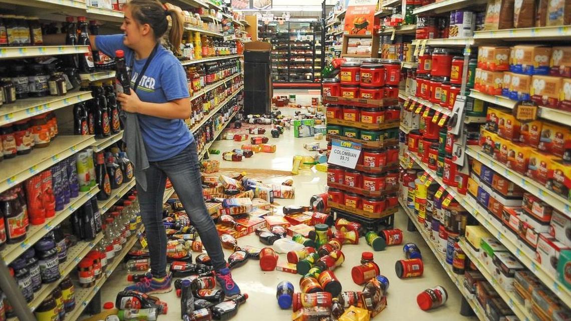 Employee Talia Pershall, 16, puts syrup back on a shelf while cleaning up at White’s Foodliner grocery store on Saturday in Pawnee, Okla., after a 5.6 magnitude earthquake in north-central Oklahoma.