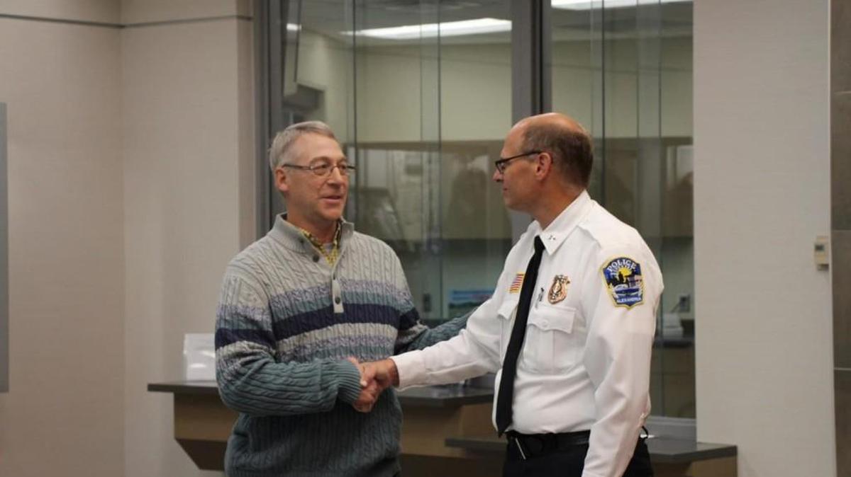 Earl Melchert, left, shakes hands with Alexandria, Minnesota Police Chief Richard Wyffels on Friday as they both presented a reward to the family of a kidnapped girl who escaped captivity after 29 days.